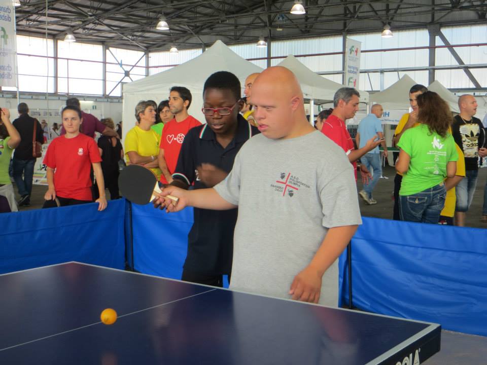 Jhonny Oyebode della rappresentativa giovanile sarda insegna  i rudimenti del Tennistavolo ad un atleta degli Special Olympics